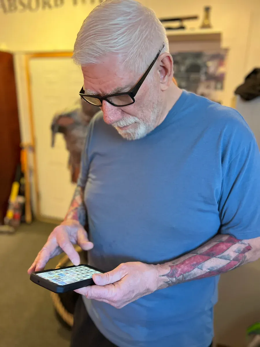 John Blee reading messages on his phone at the studio